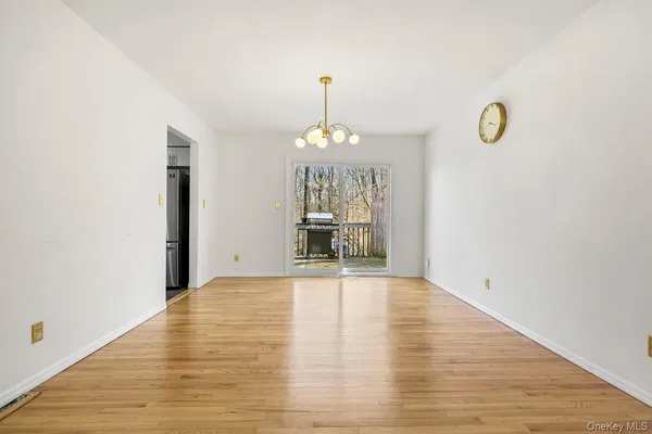 a view of an empty room with wooden floor and windows