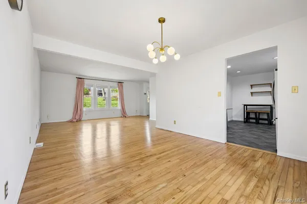 a view of a room with wooden floor and ceiling fan