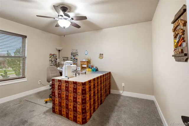 a view of a dining room with furniture and a chandelier fan