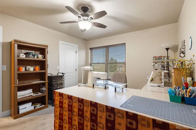 a view of a dining room with furniture and a chandelier fan