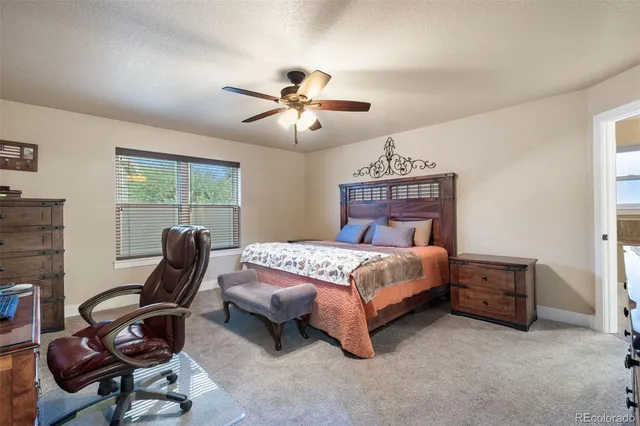 a bedroom with a bed a chair and a chandelier