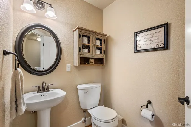 a bathroom with a toilet a sink and mirror