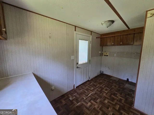 a view of an empty room with closet and a window