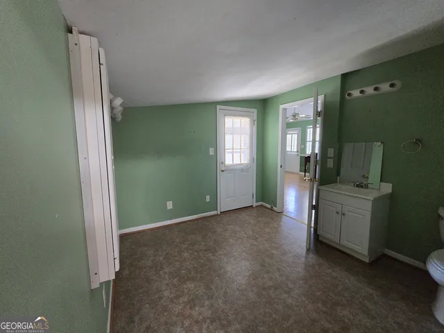 a view of a livingroom with wooden floor a ceiling fan and staircase