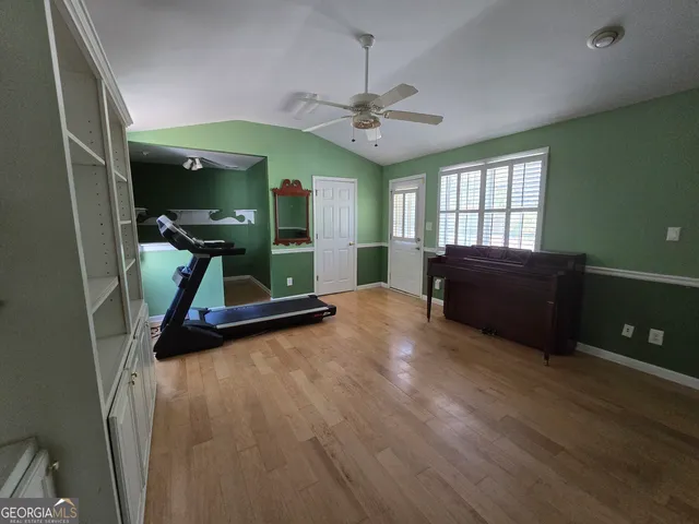 a view of a livingroom with furniture a ceiling fan and wooden floor