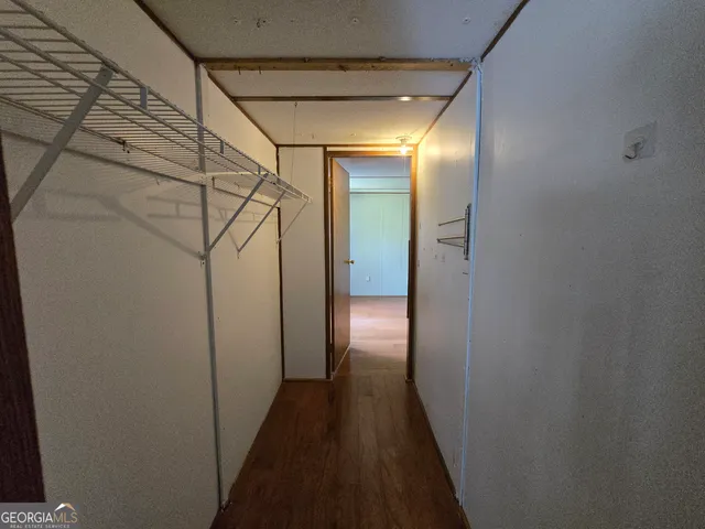 a view of a backyard with large trees and wooden fence