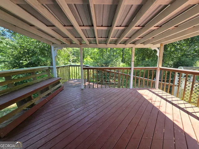 a view of a backyard with plants and large trees