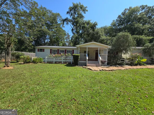a view of a house with backyard and sitting area