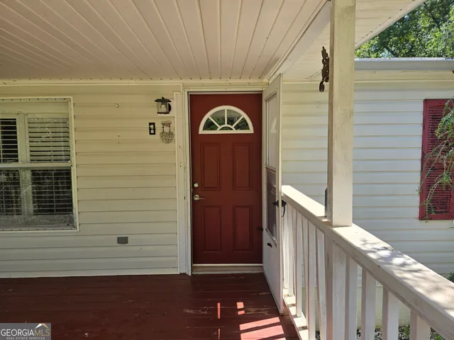 a view of house with yard and trees in the background