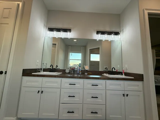 a bathroom with double sink and a mirror