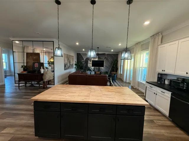 a large kitchen with kitchen island a counter space a sink stainless steel appliances and cabinets