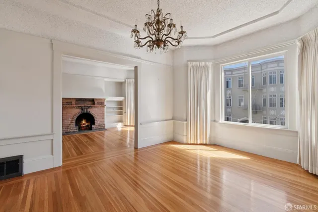 a view of a livingroom with wooden floor and a fireplace