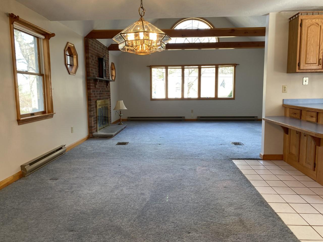 35 Catskill Road Buzzards Bay, MA 02532 - Photo 19 of 43 an empty room with windows chandelier and fireplace
