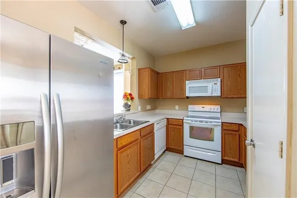 a kitchen with stainless steel appliances granite countertop a refrigerator and a sink