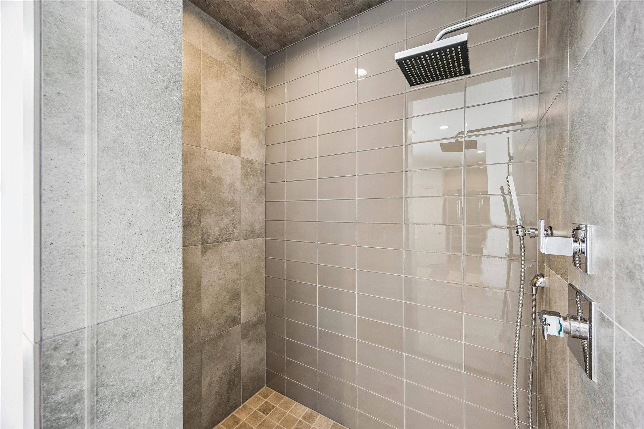 1810 Ridgewood Street Houston, TX 77006 - Photo 19 of 30 The generously sized walk-in shower features a floor-to-ceiling glass tile accent wall with porcelain tile surround. A rain-tree showerhead and handheld sprayer complete the space.
