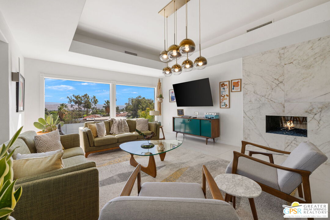 775 West Racquet Club Road Palm Springs, CA 92262 - Photo 11 of 44 a living room with furniture a fireplace and a flat screen tv