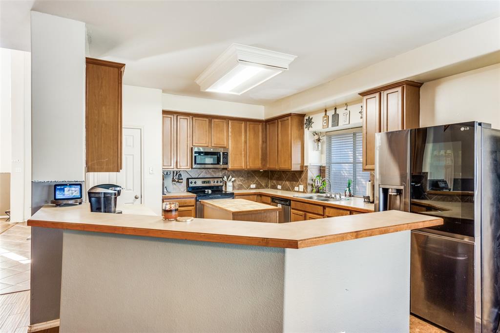 819 Hickory Street Burleson, TX 76028 - Photo 9 of 24 a kitchen with stainless steel appliances a sink stove and cabinets