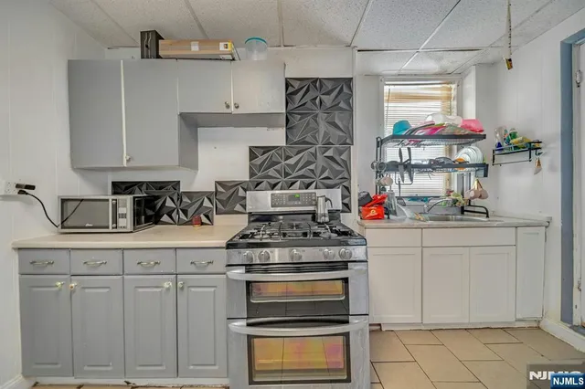 a kitchen with white cabinets and appliances