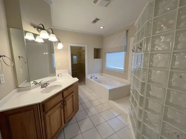 a bathroom with a tub a sink and a shower
