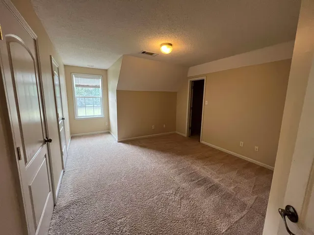 an empty room with a windows and cabinet