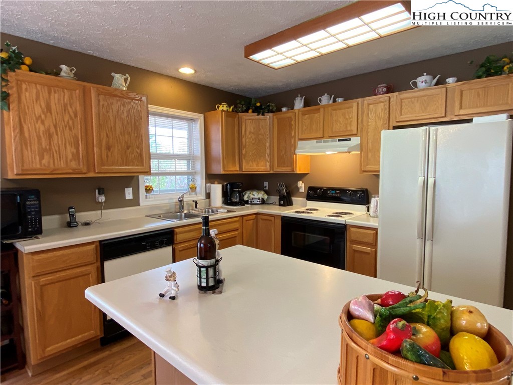 1241 Glade Creek School Road Ennice, NC 28623 - Photo 13 of 49 a kitchen with stainless steel appliances granite countertop a sink window and cabinets