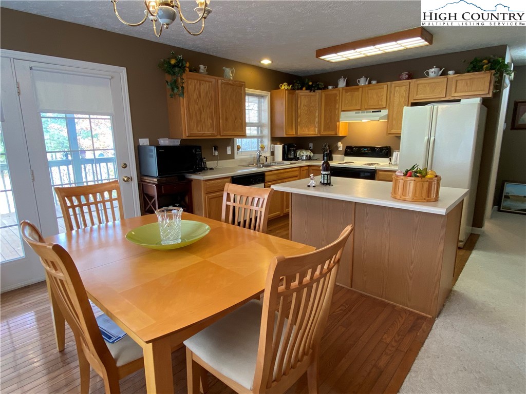 1241 Glade Creek School Road Ennice, NC 28623 - Photo 14 of 49 a kitchen with stainless steel appliances granite countertop a sink a stove a kitchen island with chairs and wooden floor