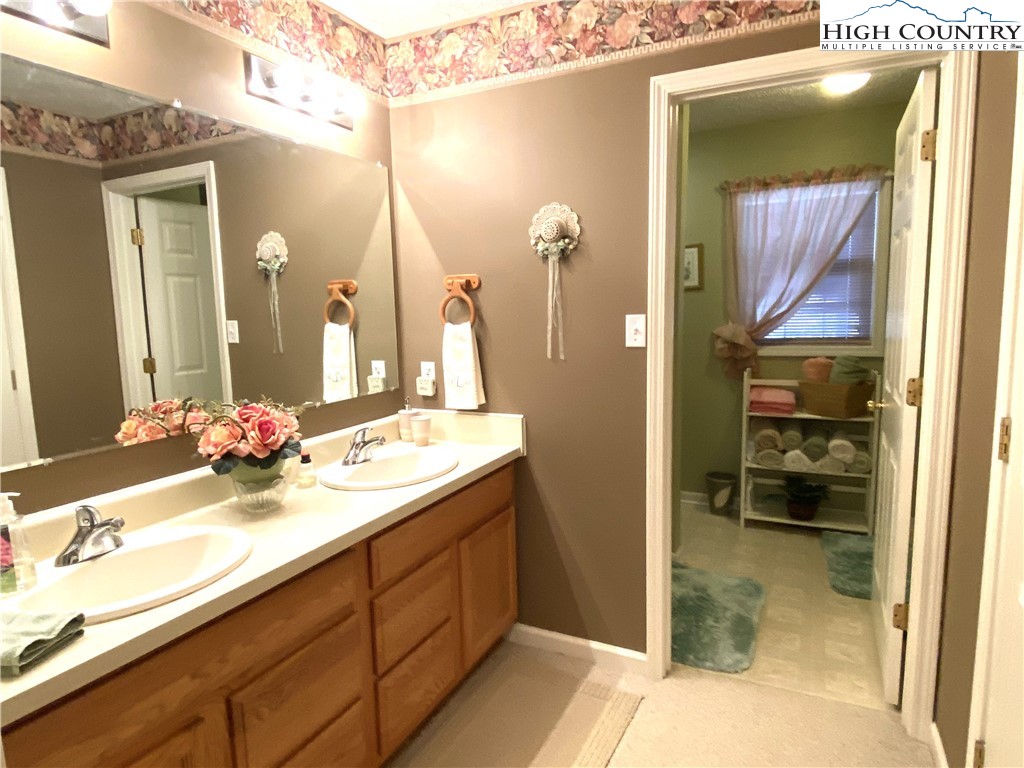 1241 Glade Creek School Road Ennice, NC 28623 - Photo 19 of 49 a bathroom with a sink a mirror and a shower