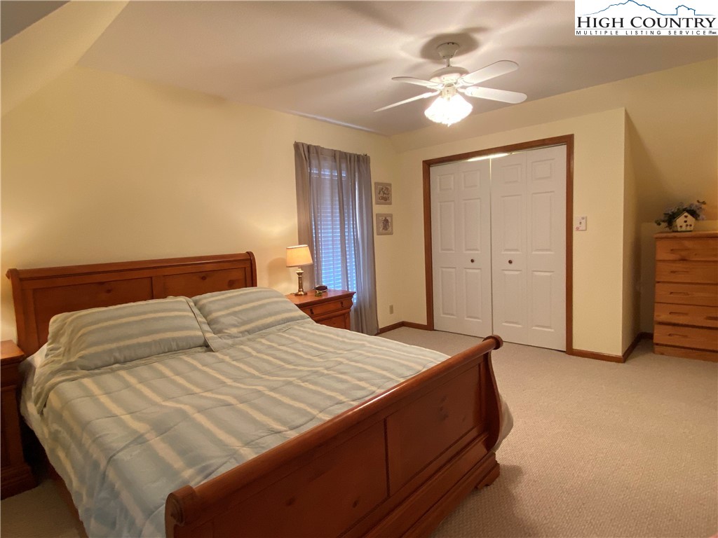 1241 Glade Creek School Road Ennice, NC 28623 - Photo 27 of 49 a bedroom with a bed and a chandelier