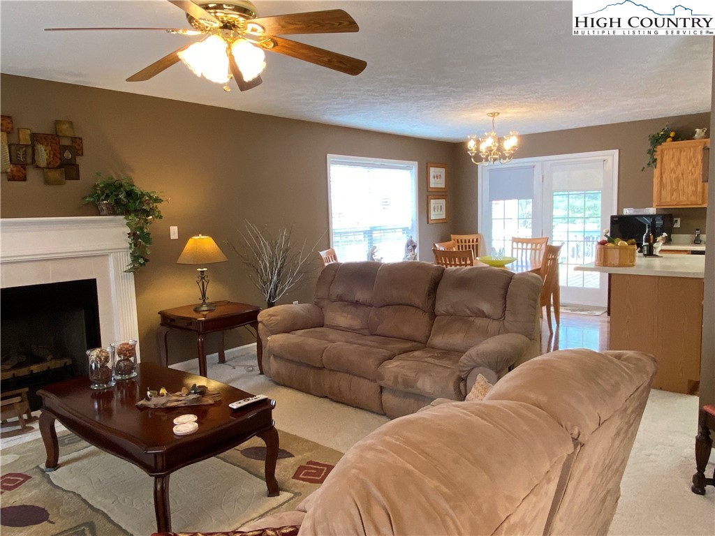 1241 Glade Creek School Road Ennice, NC 28623 - Photo 8 of 49 a living room with couches a fireplace and a flat screen tv