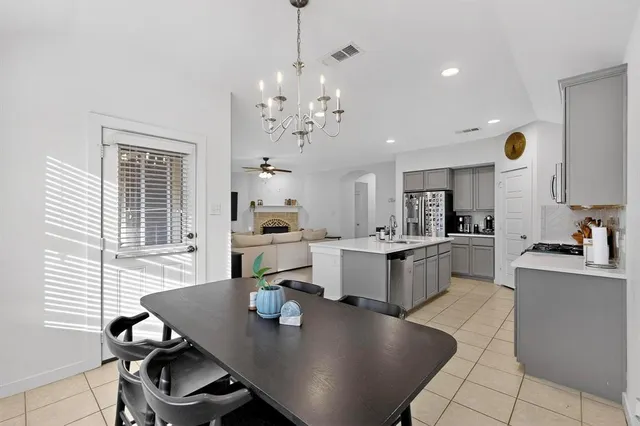 a open dining room with kitchen island stainless steel appliances furniture large window and wooden floor
