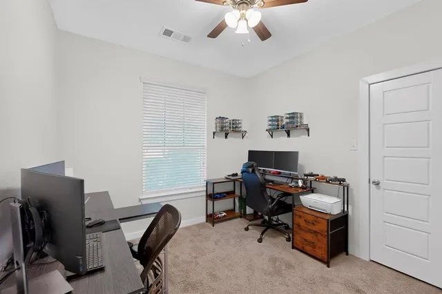 a view of a workspace with furniture and a window