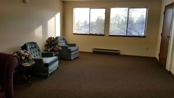 a living room with furniture and two windows