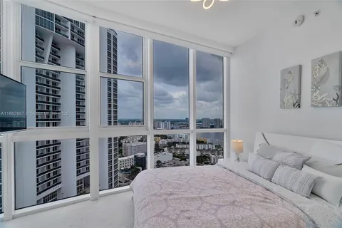 a large bedroom with a bed and a large window