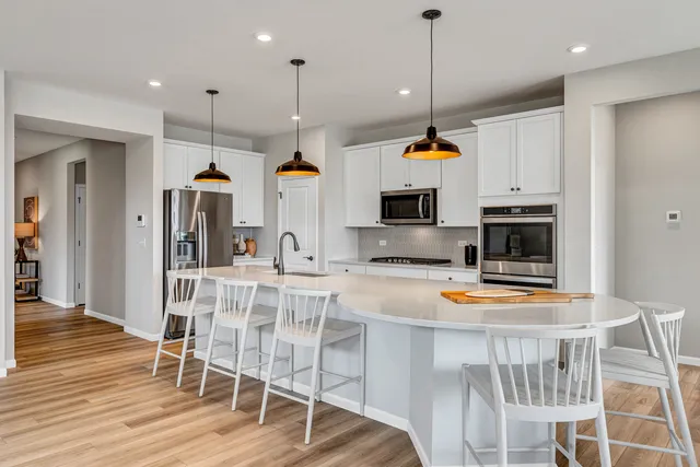 a kitchen with stainless steel appliances kitchen island granite countertop a stove a sink and a wooden floors
