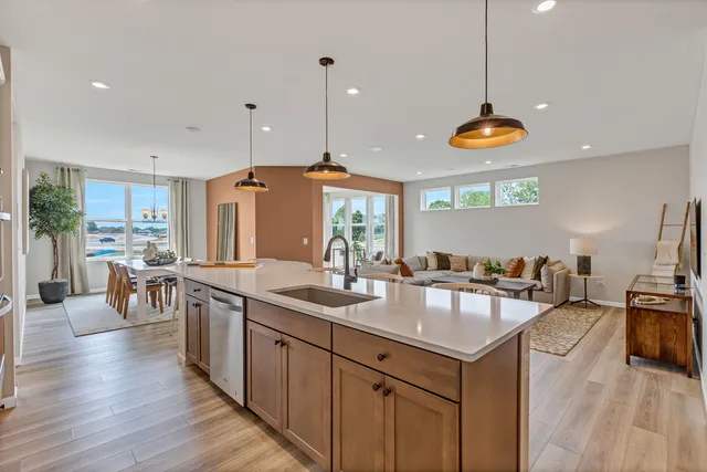 a kitchen with lots of counter space a sink appliances and living room view