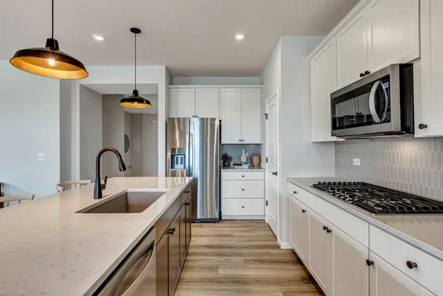 a kitchen with stainless steel appliances granite countertop a sink a stove and a refrigerator