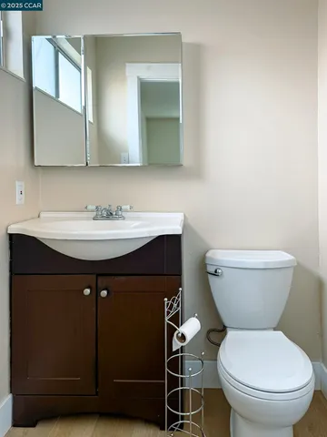 a bathroom with a toilet a sink and mirror