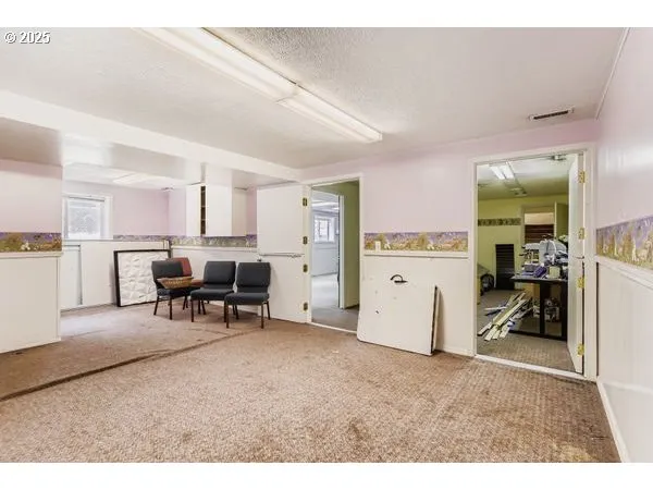 a view of a white house with a big yard and large tree