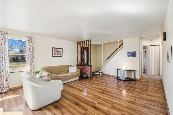 a living room with furniture and a wooden floor