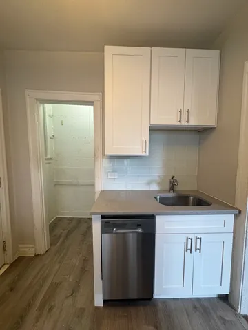 a kitchen with granite countertop white cabinets and a sink
