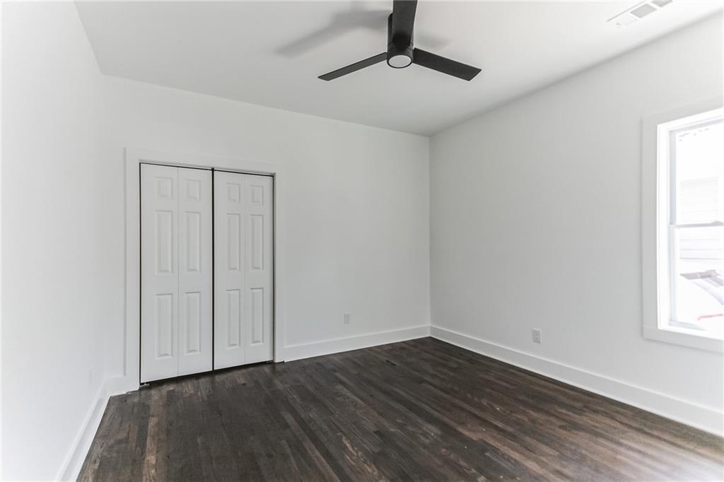 1252 Epworth Street Southwest Atlanta, GA 30310 - Photo 11 of 19 an empty room with wooden floor cabinet and windows