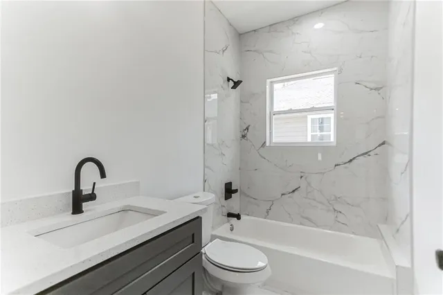 a bathroom with a bathtub shower sink mirror and toilet