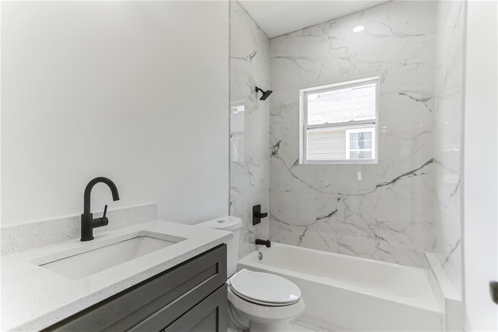 1252 Epworth Street Southwest Atlanta, GA 30310 - Photo 13 of 19 a bathroom with a bathtub shower sink mirror and toilet