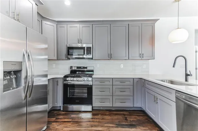 a kitchen with stainless steel appliances granite countertop a stove a sink and a refrigerator