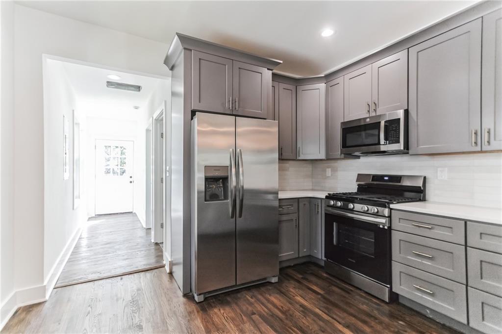 1252 Epworth Street Southwest Atlanta, GA 30310 - Photo 8 of 19 a kitchen with stainless steel appliances granite countertop a stove a refrigerator and a microwave