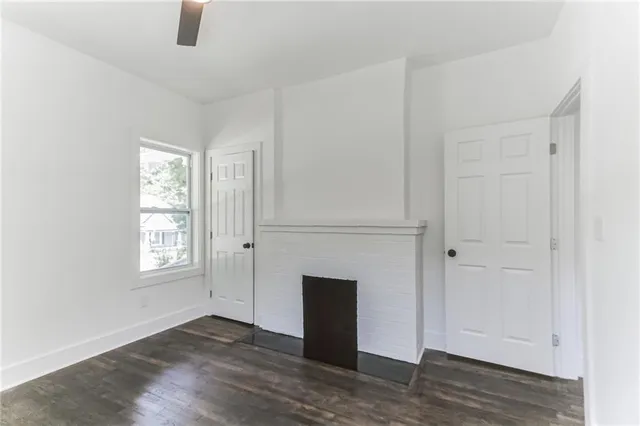 an empty room with windows closet and fireplace