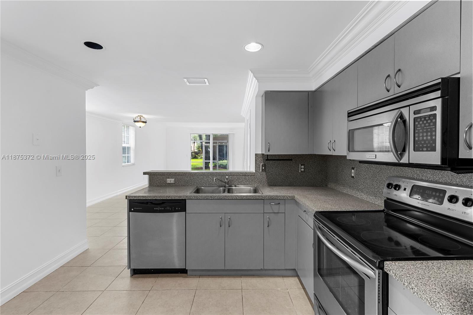 1440 Coronado Road, Unit 138 Weston, FL 33327 - Photo 11 of 38 a kitchen with a stove sink and microwave