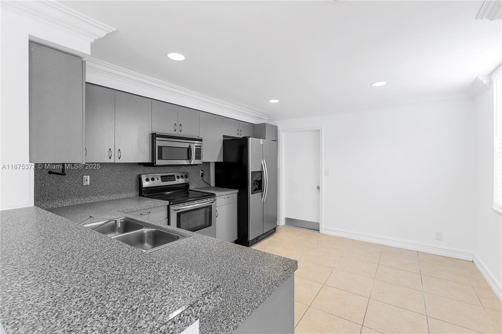 1440 Coronado Road, Unit 138 Weston, FL 33327 - Photo 12 of 38 a kitchen with stainless steel appliances granite countertop a stove a sink and a refrigerator