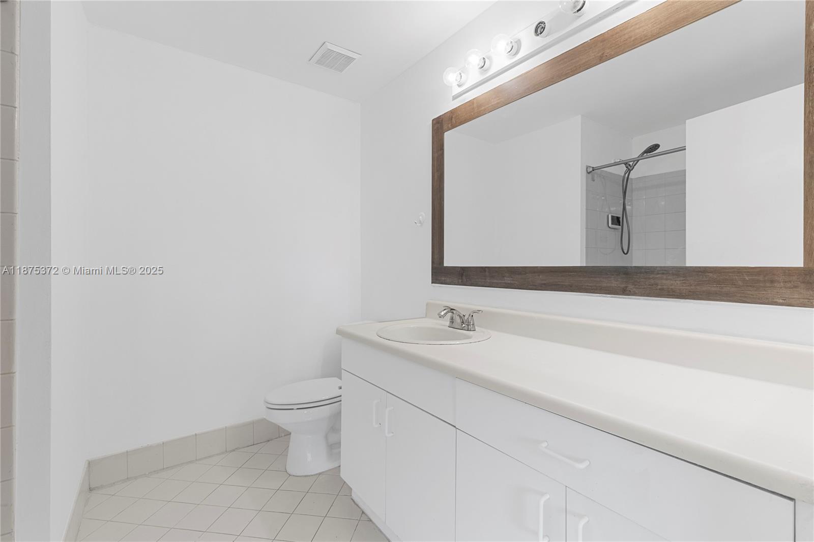 1440 Coronado Road, Unit 138 Weston, FL 33327 - Photo 23 of 38 a bathroom with a toilet sink and mirror