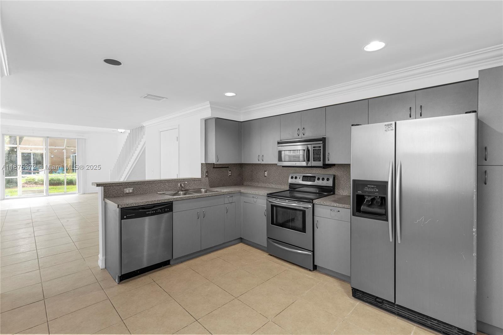 1440 Coronado Road, Unit 138 Weston, FL 33327 - Photo 10 of 38 a kitchen with granite countertop stainless steel appliances and white cabinets